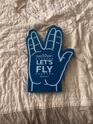 A foam finger/hand in the style of a Vulcan salute. On it, it says “Star Trek: Discovery | Let’s Fly”.