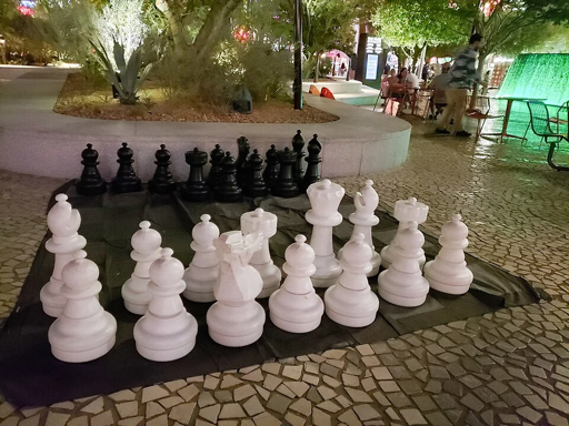 A large-sized chess set on a public plaza.