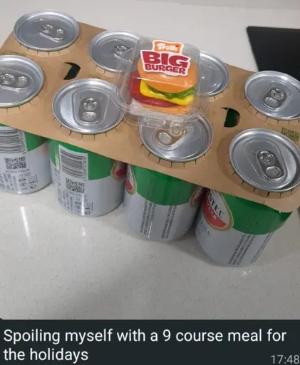 An eight pack of cheap beer cans and a tiny gummy candy burger. The caption reads "Spoiling myself with a 9 course meal for the holidays"
